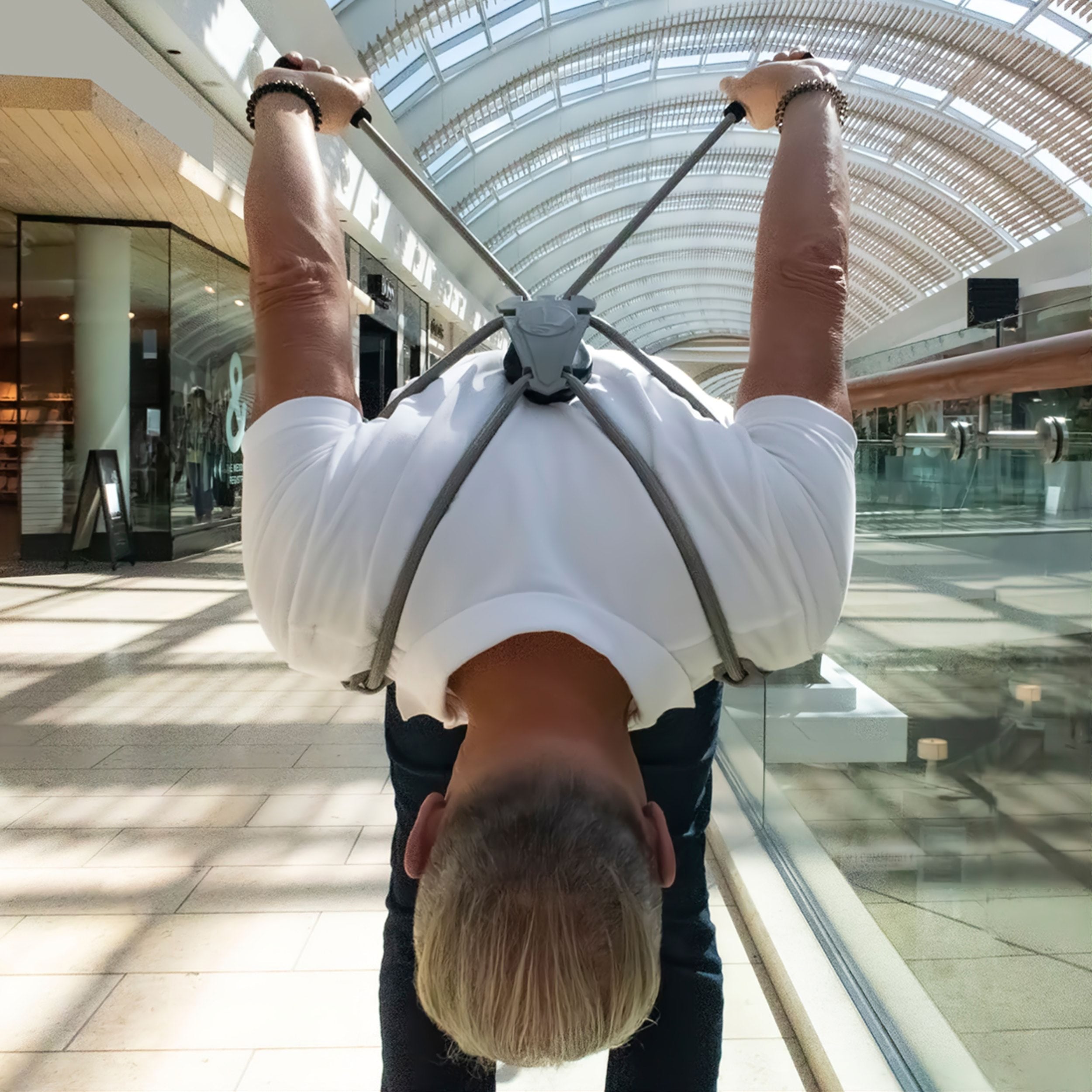 A person with The Back Transformer neck posture brace doing stretches in a mall.